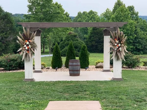 Outdoor wedding ceremony setup at Mountain Ridge Venue with floral arrangements and barrel decor.