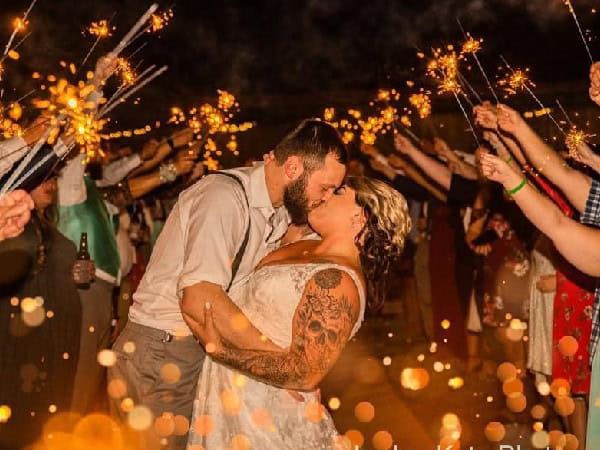 Couple kissing at Mountain Ridge Venue during wedding with sparklers.