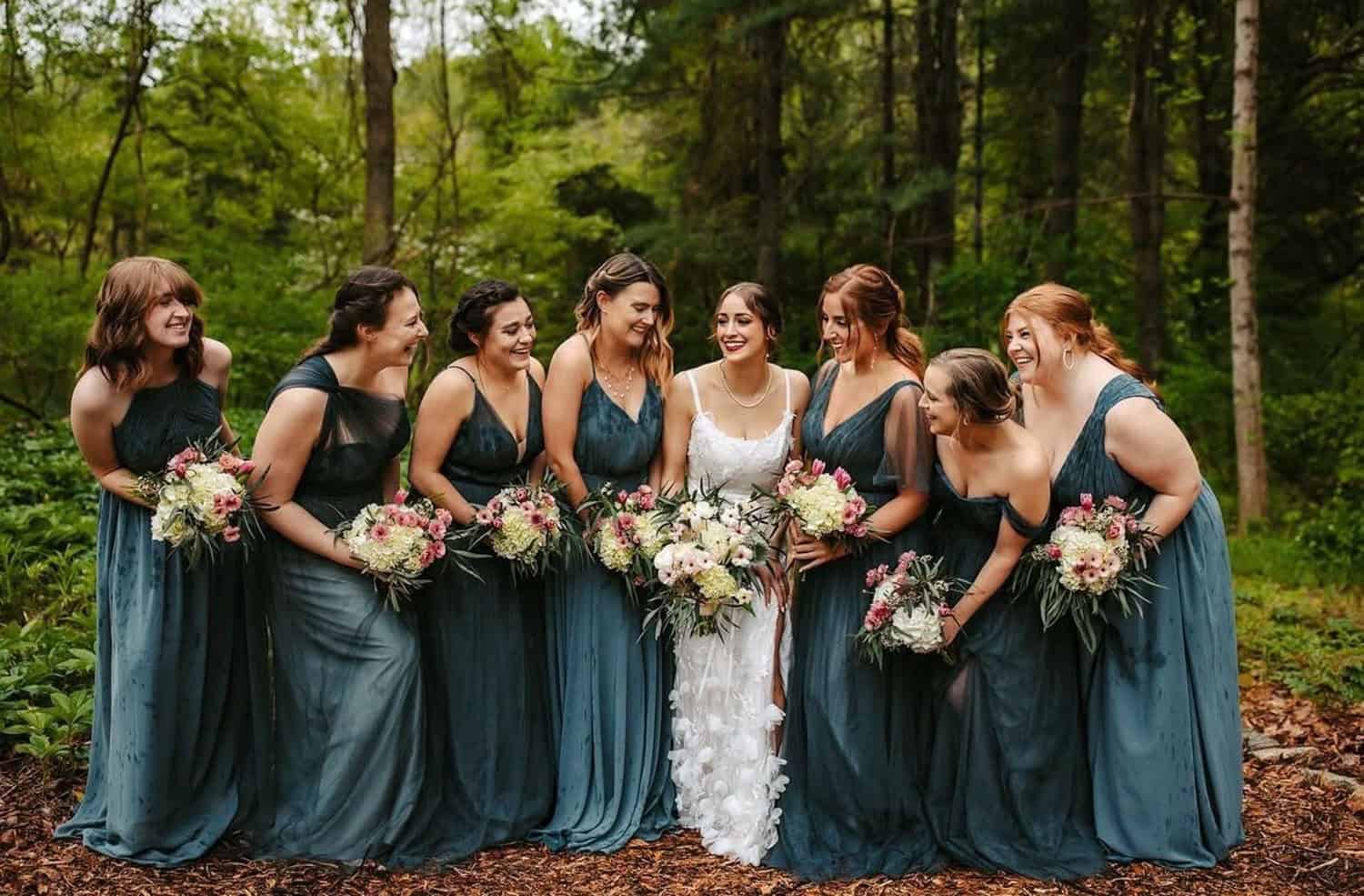 Bridal party in forest at Mountain Ridge Venue with bridesmaids in blue dresses.