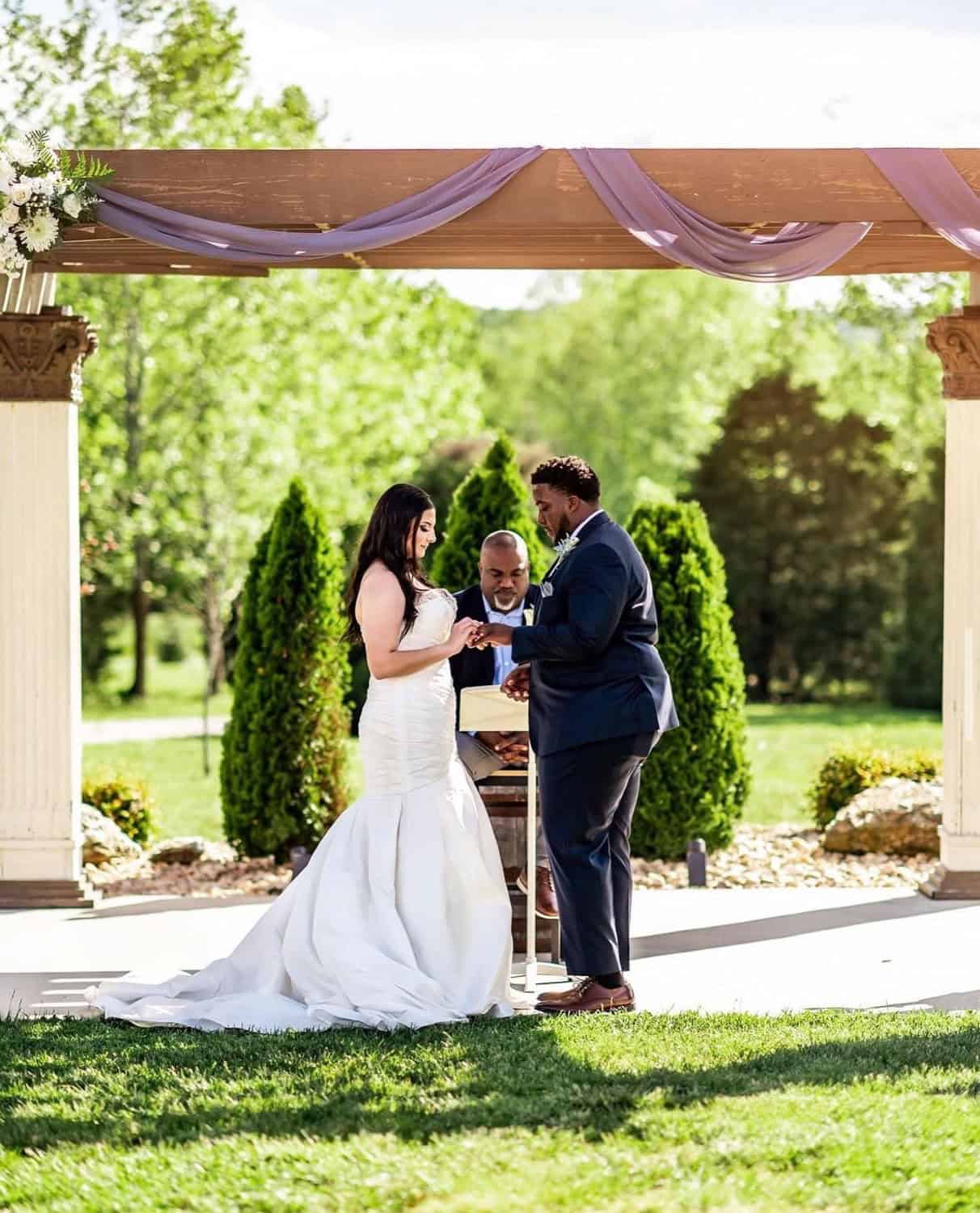Bride and groom exchanging vows at Mountain Ridge outdoor wedding venue.