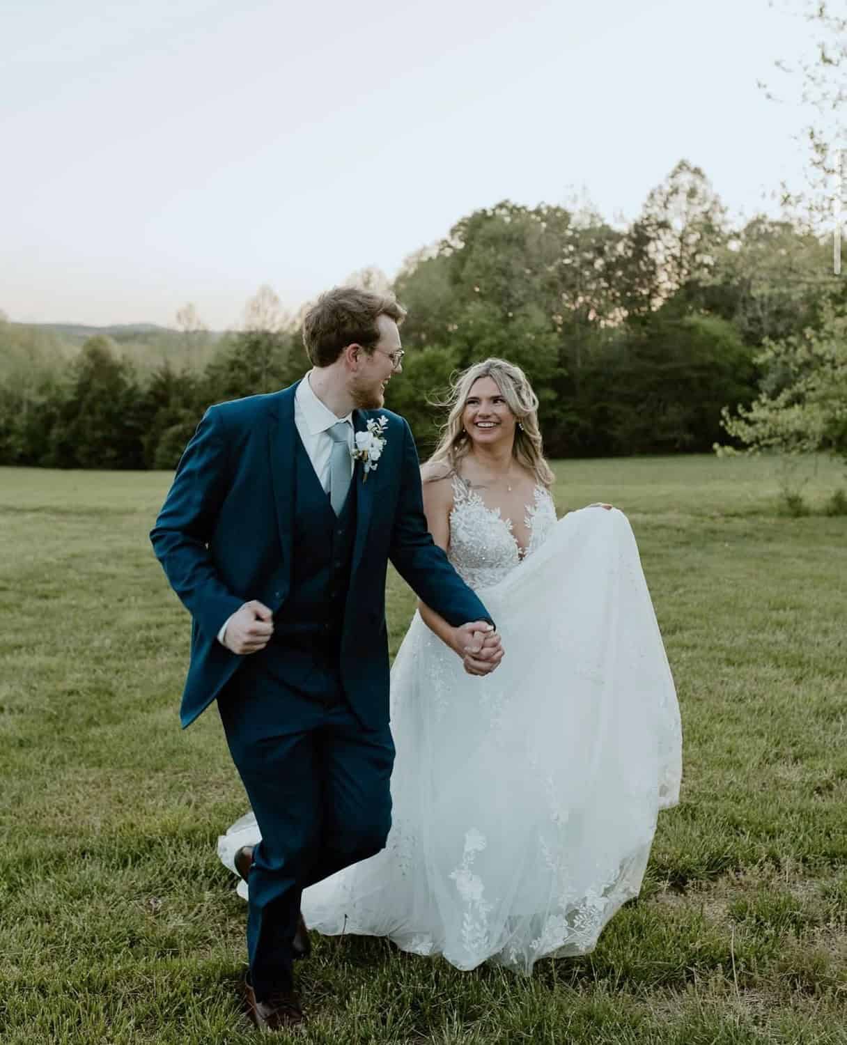 Bride and groom walking hand in hand at Mountain Ridge Venue.