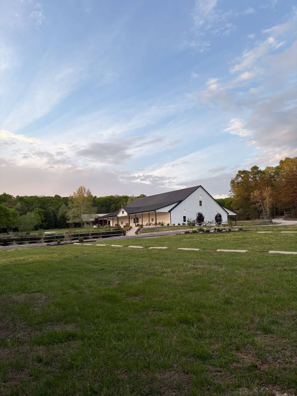 Scenic view of Mountain Ridge Venue with barn and open fields under blue sky.