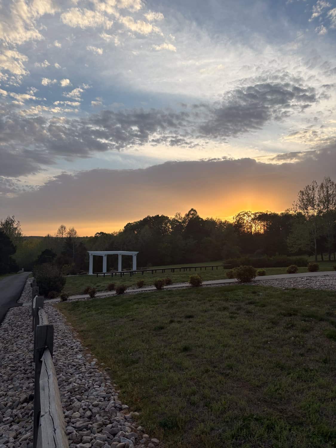 Scenic sunset view over Mountain Ridge outdoor venue with gazebo and lush landscape.