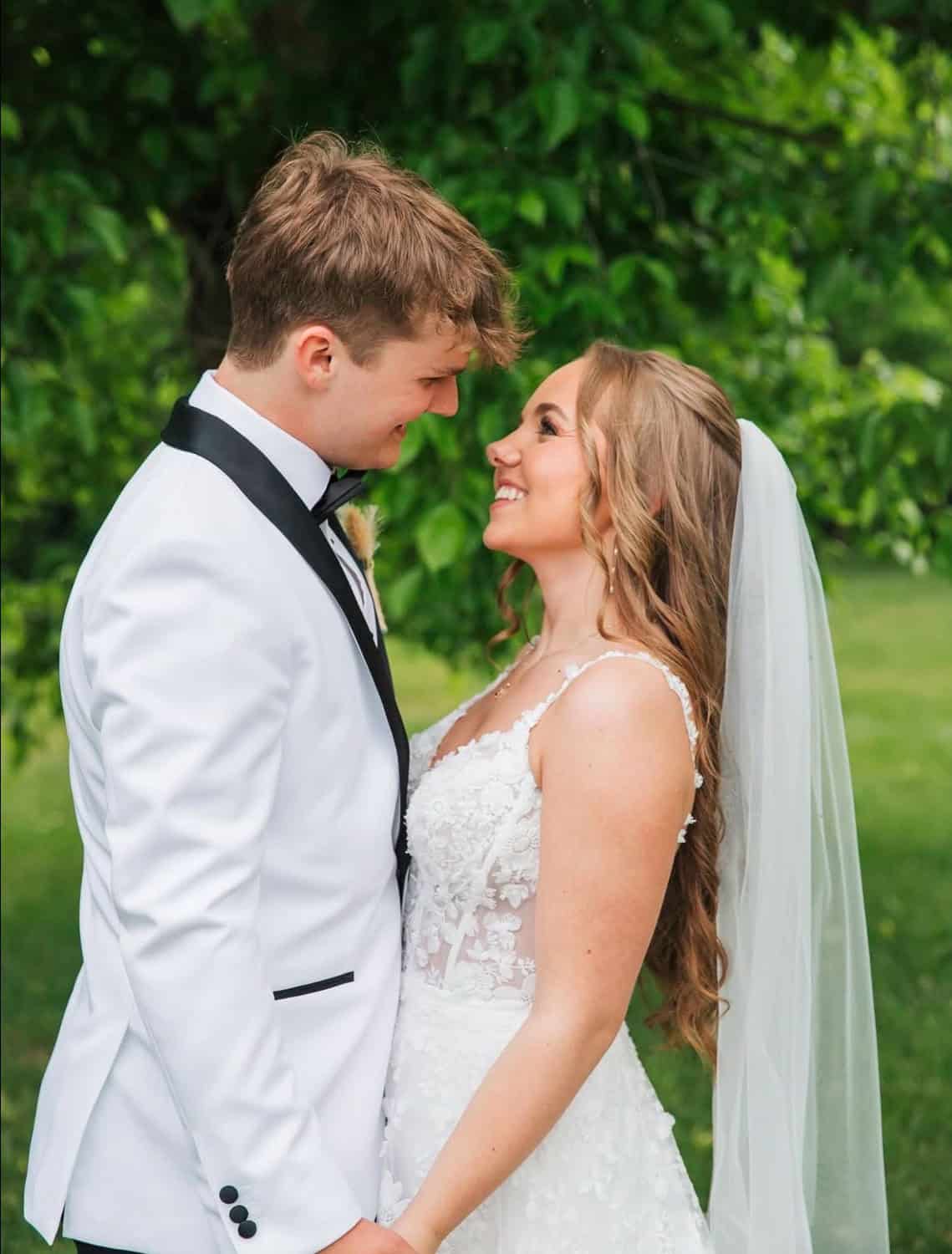 Happy bride and groom smiling at each other outdoors at Mountain Ridge Venue.