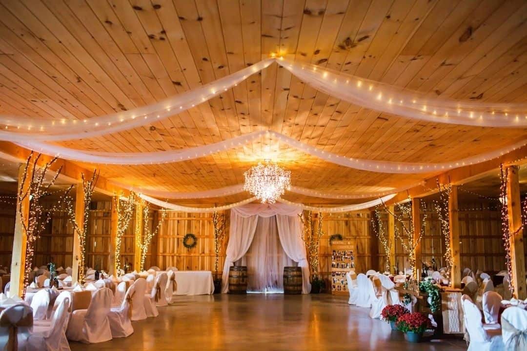 Elegant wedding reception hall at Mountain Ridge Venue with draped ceiling and chandelier.