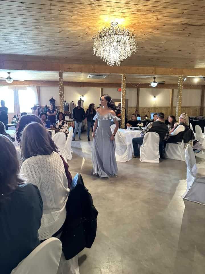 Elegant woman in gown at Mountain Ridge Venue event with chandelier lighting.