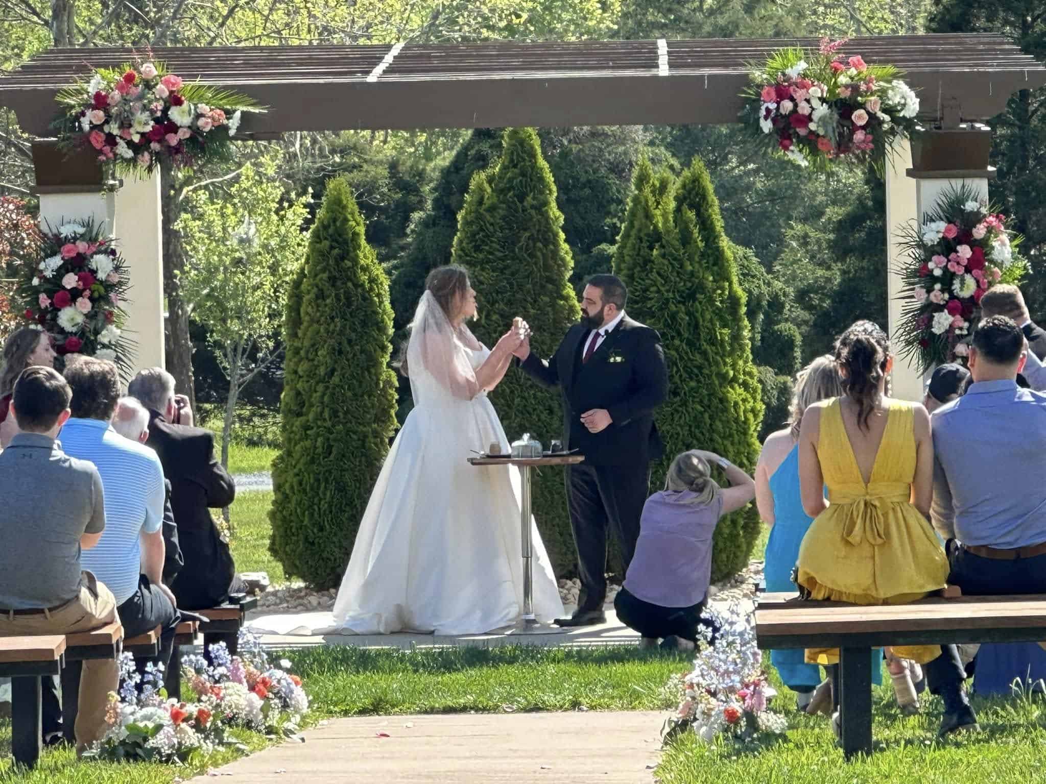 Outdoor wedding ceremony at Mountain Ridge Venue with floral decorations.